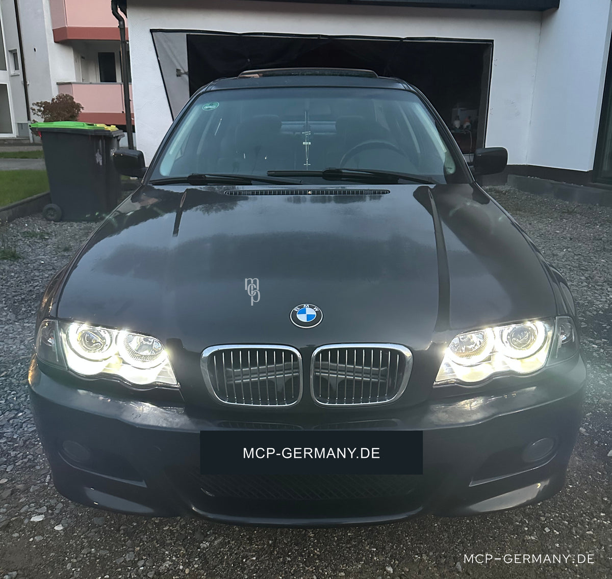 MCP 031242 – Angel Eyes Scheinwerfer mit Frontblinkern BMW 3er E46 Limousine/Touring Schwarz – Lichtansicht am Fahrzeug bei Tageslicht